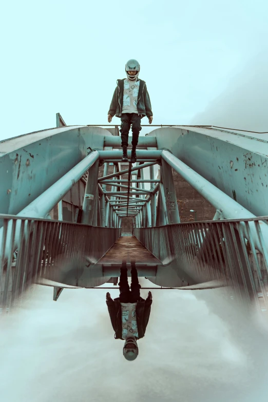 a man standing on top of a bridge in the clouds