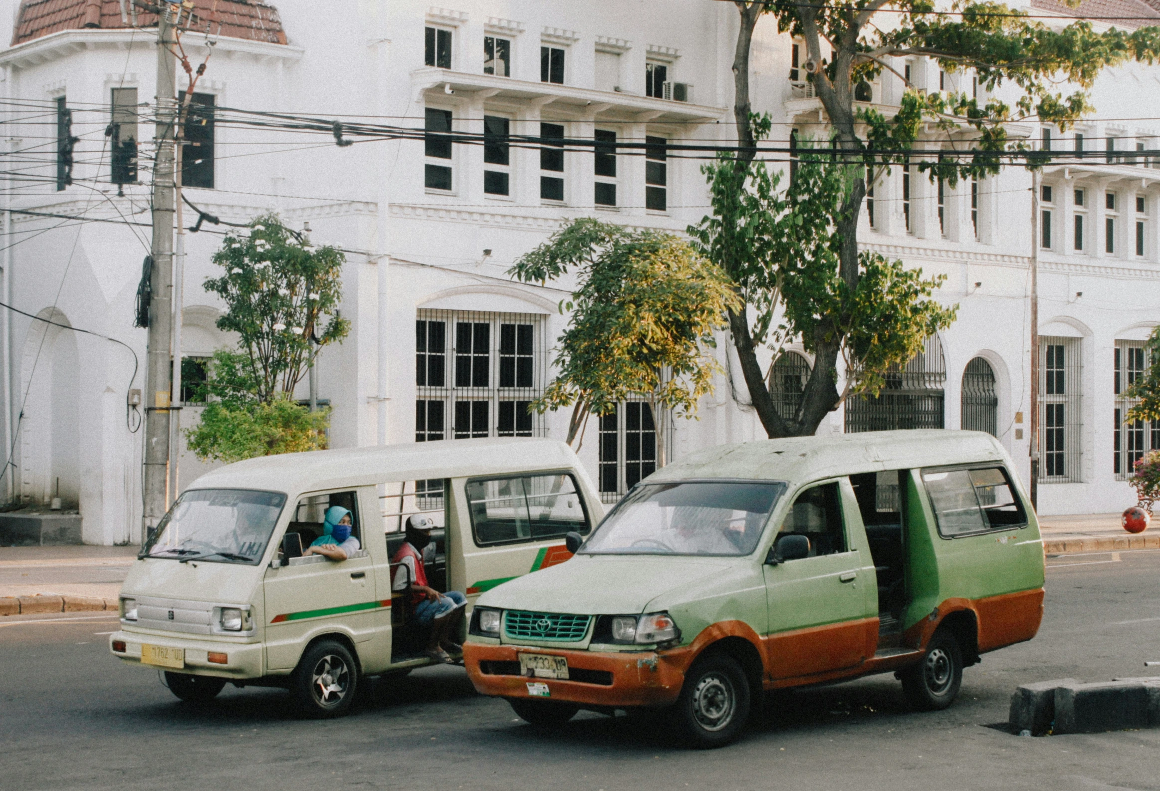 two small vans parked next to each other in a street