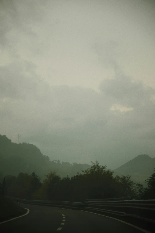 cloudy day in the mountains with a street sign pointing left