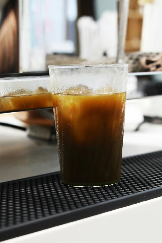 a drink sitting on top of a counter next to a mirror