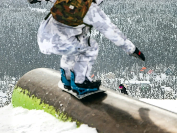 a person is snowboarding down a railing at the top of a mountain