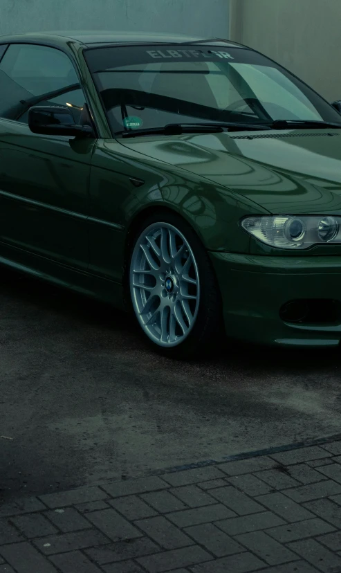 a green sports car is parked outside an office building