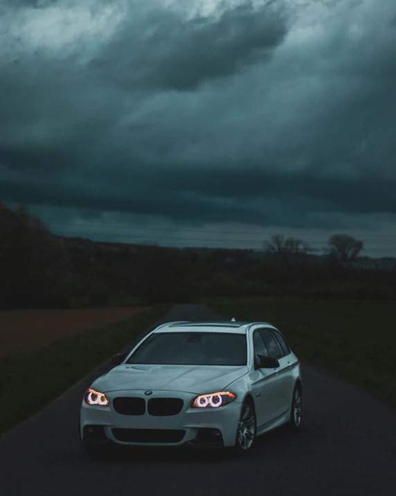 a grey car driving down the road in a field