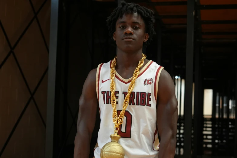 the young man wears a gold necklace and a basketball jersey