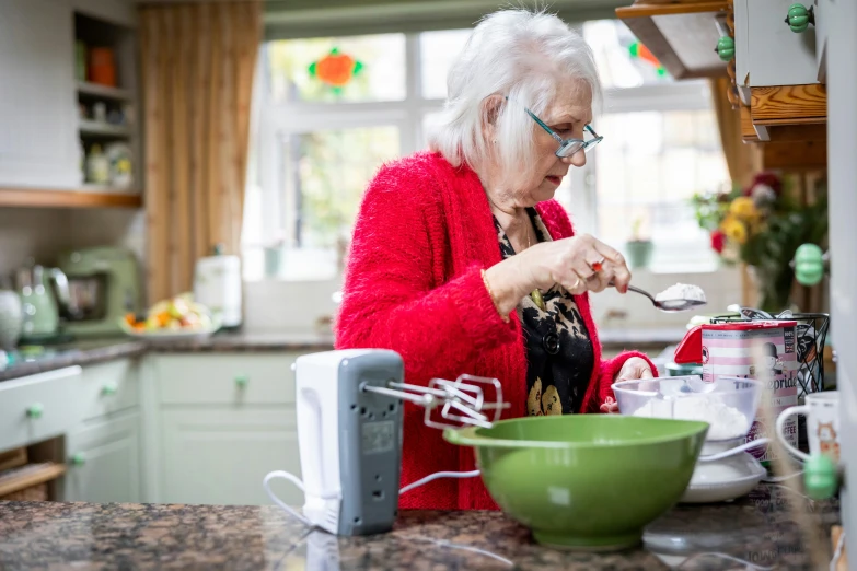 an old woman in red is in the kitchen