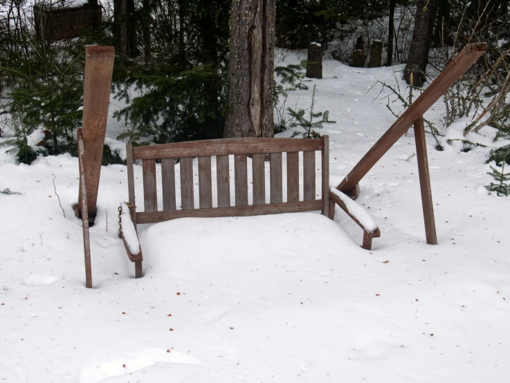 a bench is sitting in the snow near trees