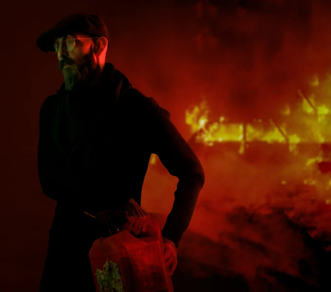 a man standing next to a bunch of fire with flames behind him