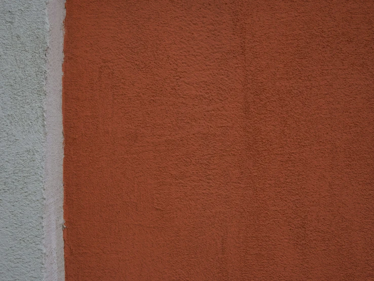 a yellow and white striped vase next to a large brown and gray wall