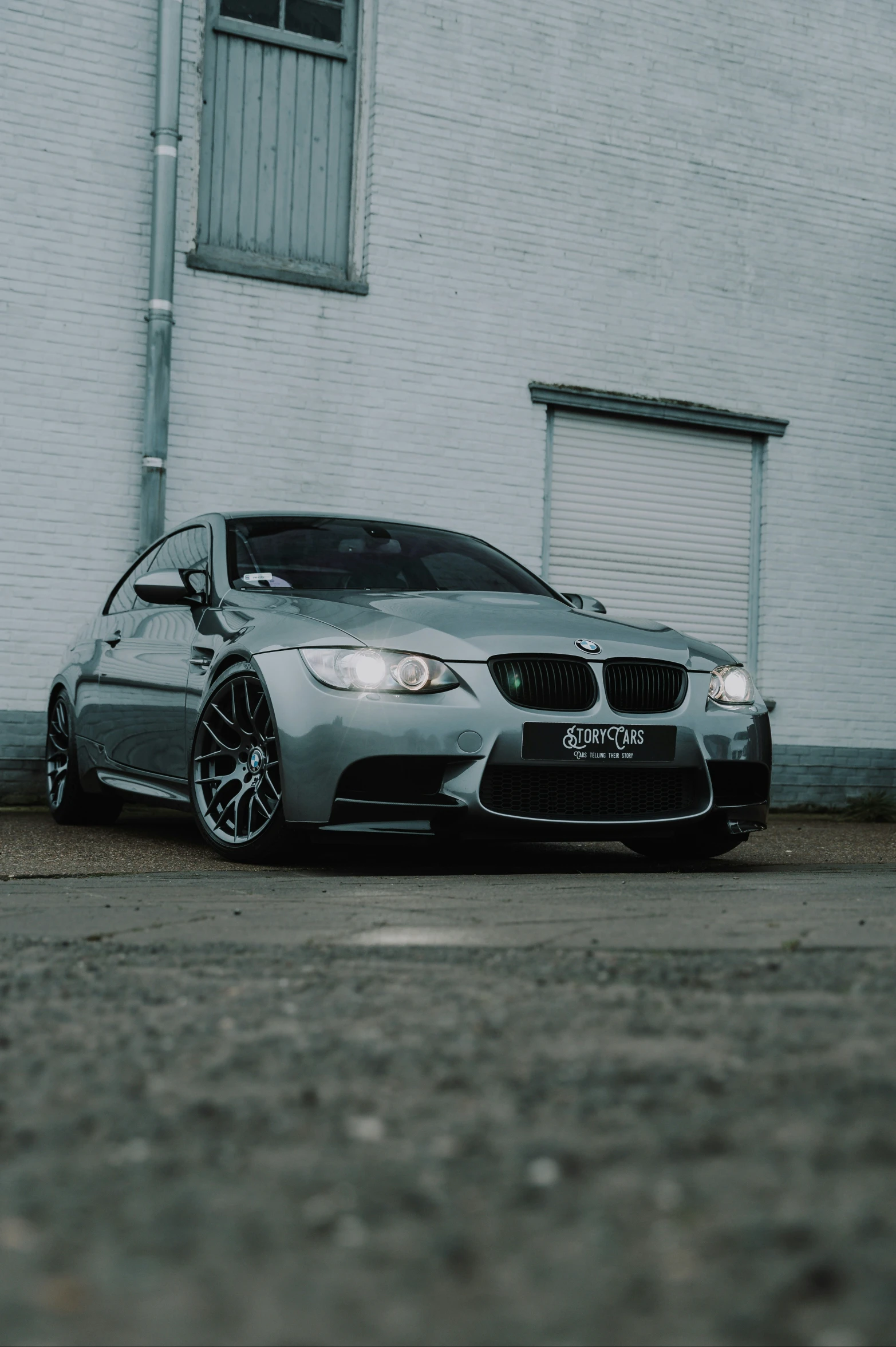 a silver bmw parked in front of a building