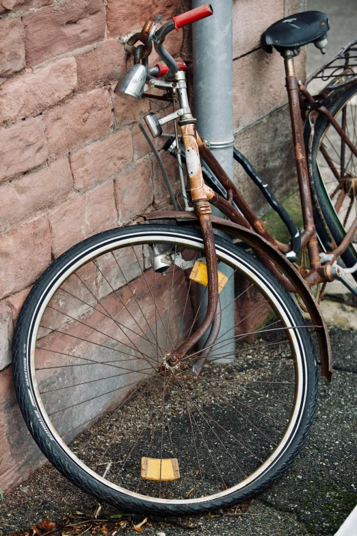 an old bike sitting outside by the corner of a building