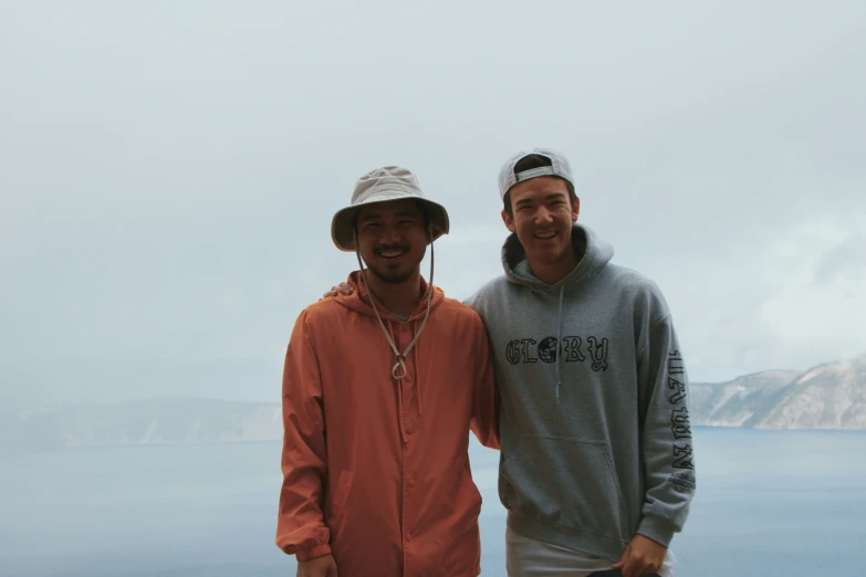 a man wearing a hat standing next to another man