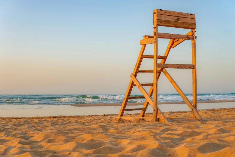 there is a ladder standing up on a sandy beach