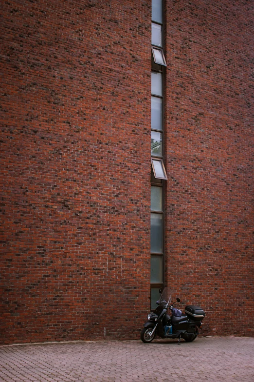 a motorcycle that is parked against a brick building