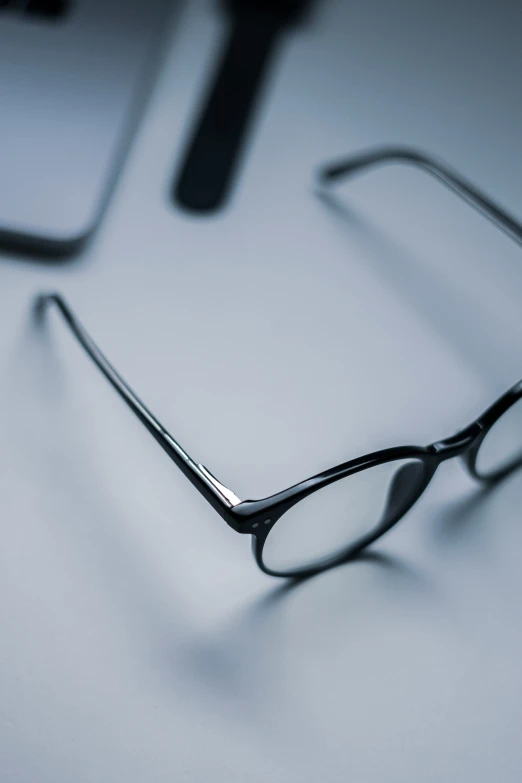 eyeglasses are resting on a table in front of a keyboard