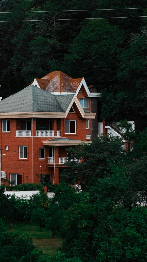 a big brown house surrounded by trees in the woods