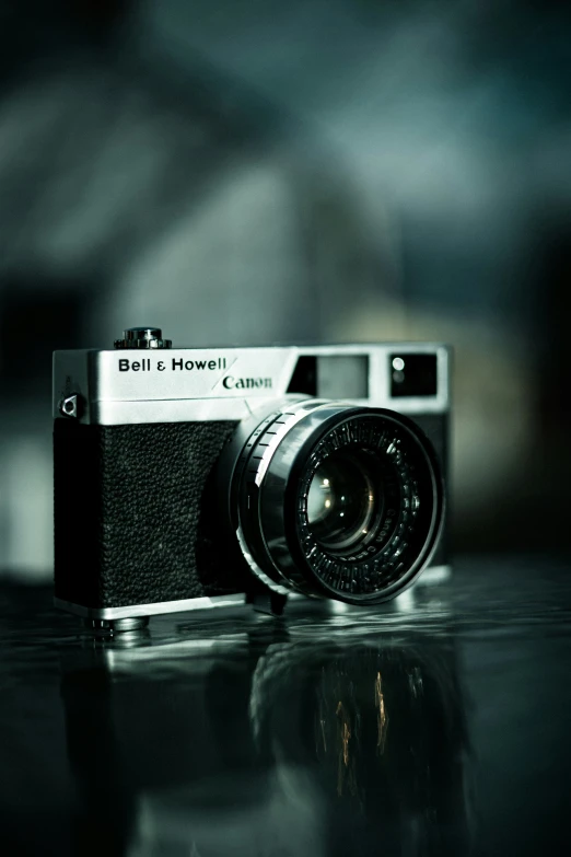 an old camera on a black surface with blurry background