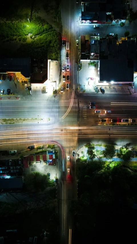 an aerial view of several cars passing at night