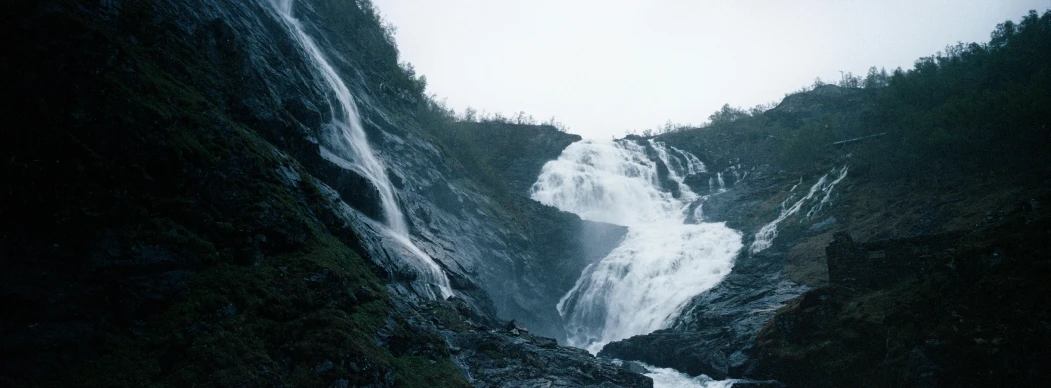 the waterfall looks like it is falling off the side of a mountain