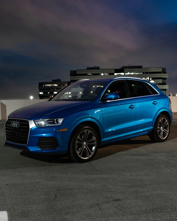 a blue car parked in a parking lot at night