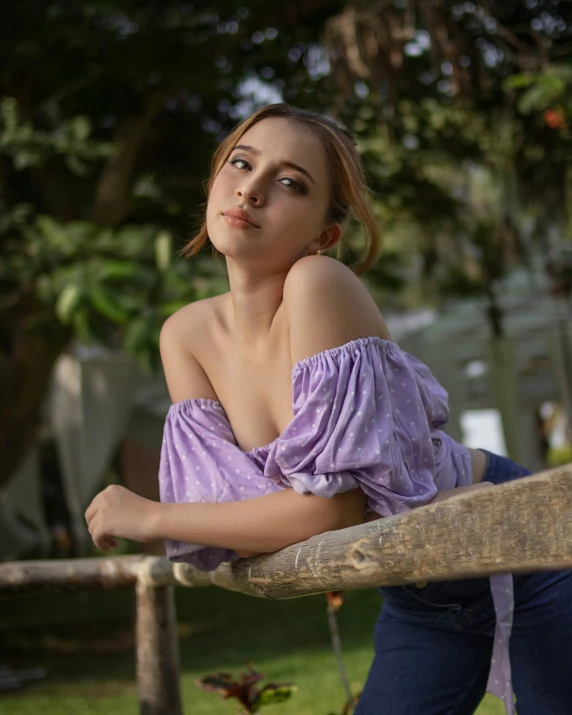 a woman leaning on a fence with a hand on her shoulder