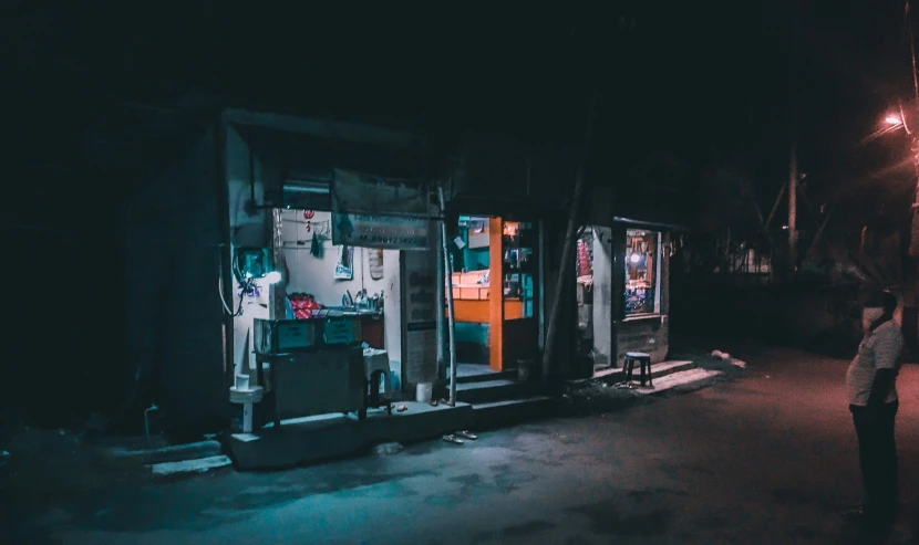 a man in black standing outside of an abandoned building