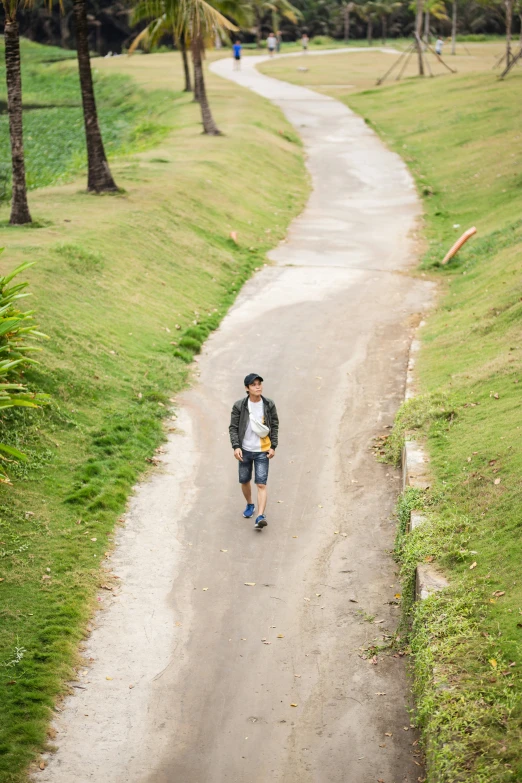 the person is walking down the narrow road