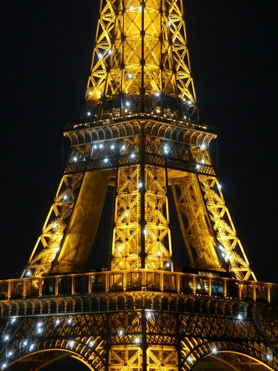 a very tall metal and glass tower lit up at night