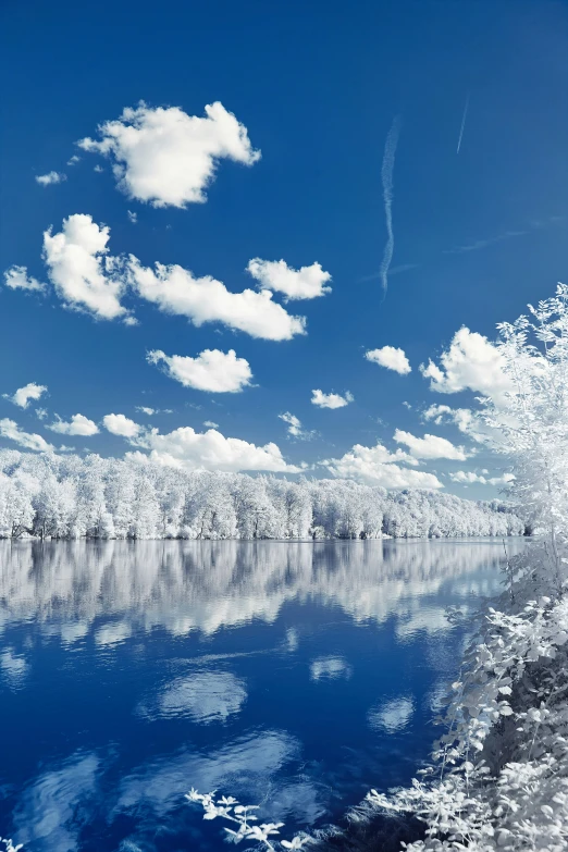 a large body of water surrounded by mountains and clouds