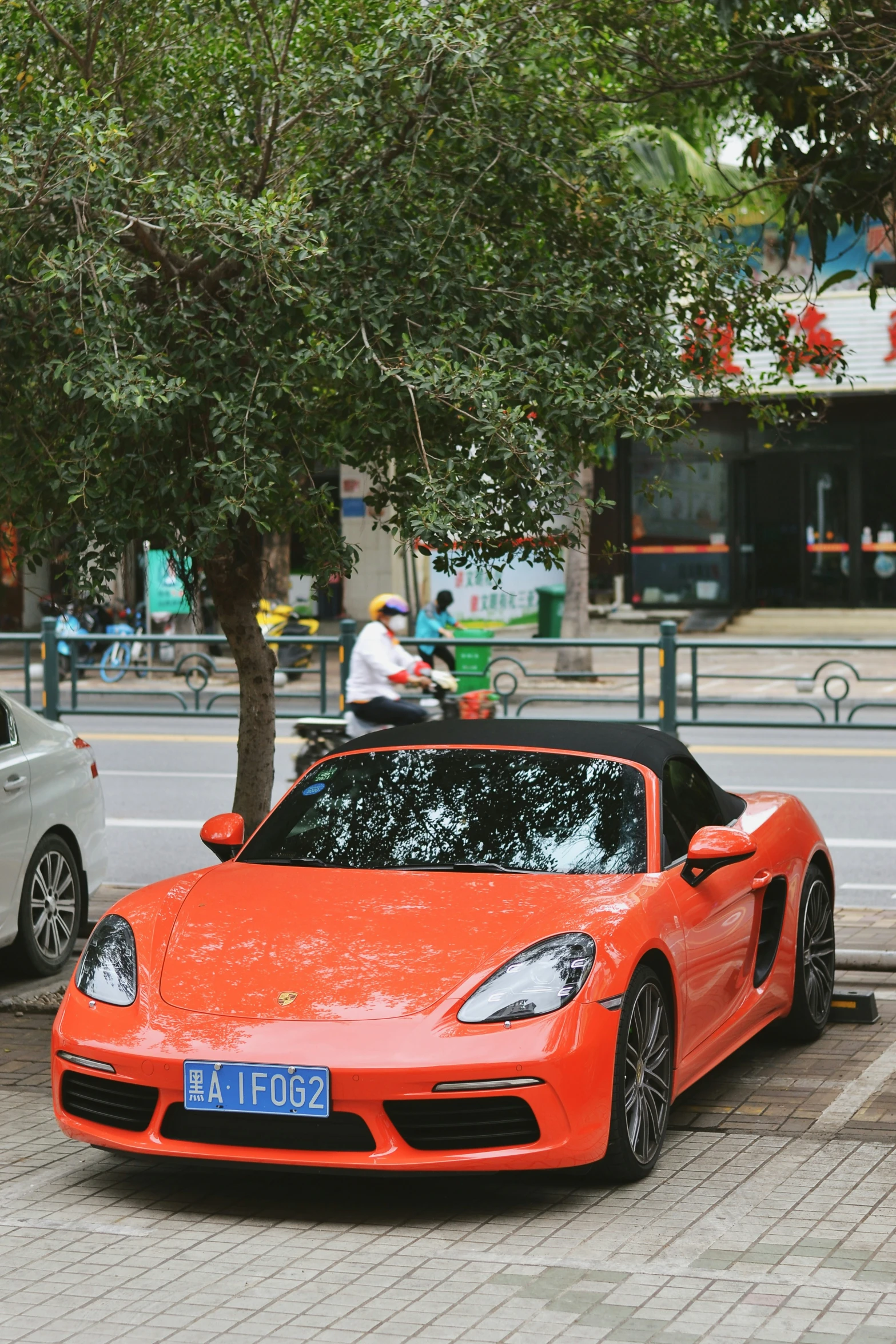 a porsche gtr convertible parked next to a tree