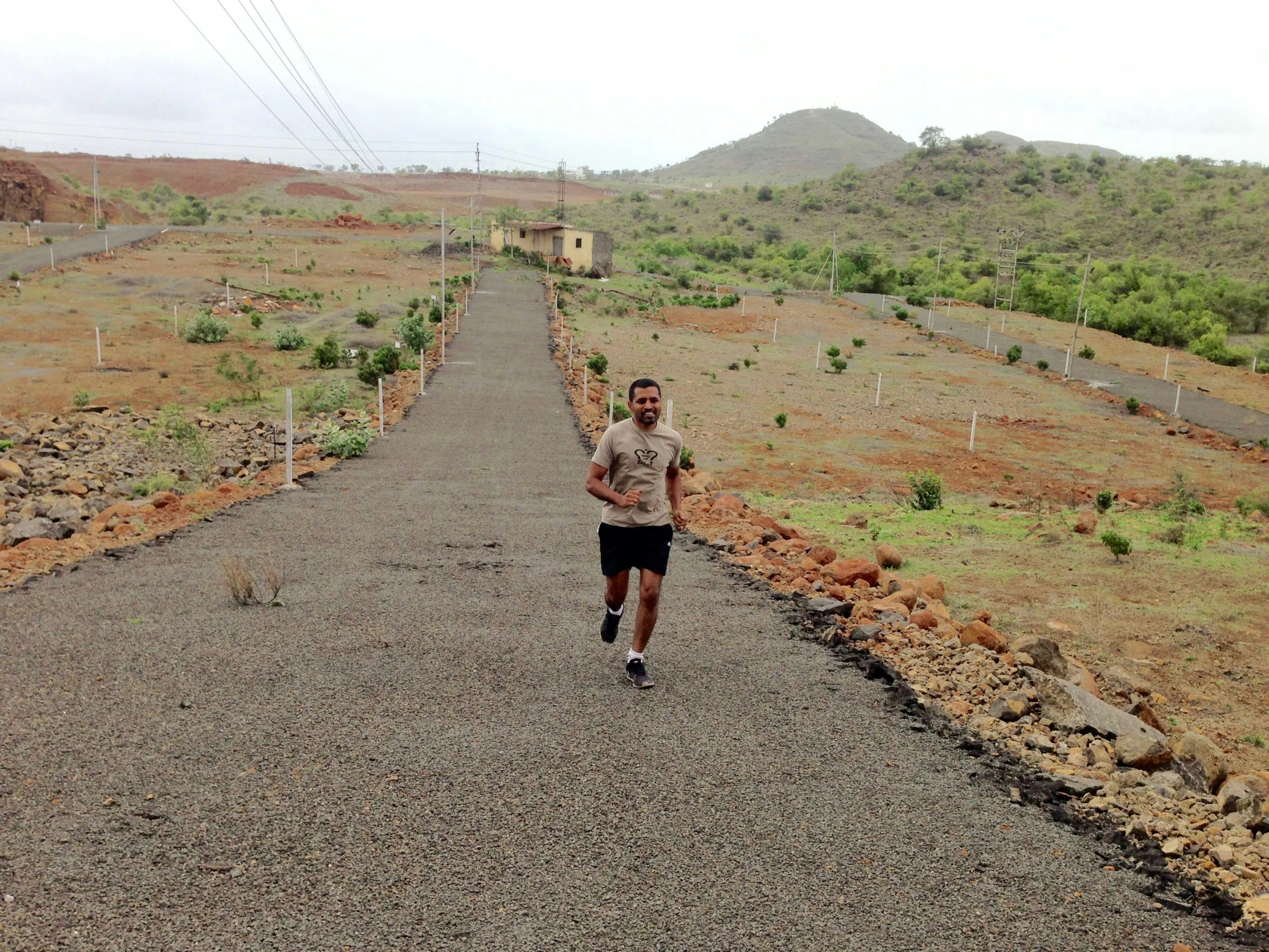 a man jogging down the side of a gravel road