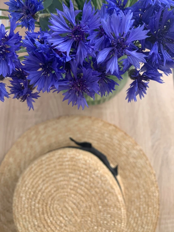 purple flowers are in a basket with straw