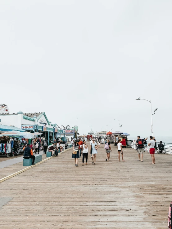 a group of people are walking on the pier