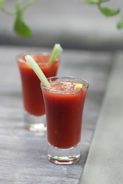 two glasses of juice sitting on top of a table