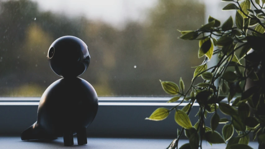 a stuffed toy sitting next to plants in front of a window