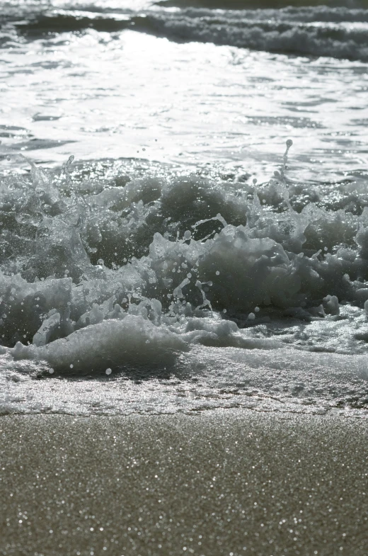 waves roll in over a beach and over the sand