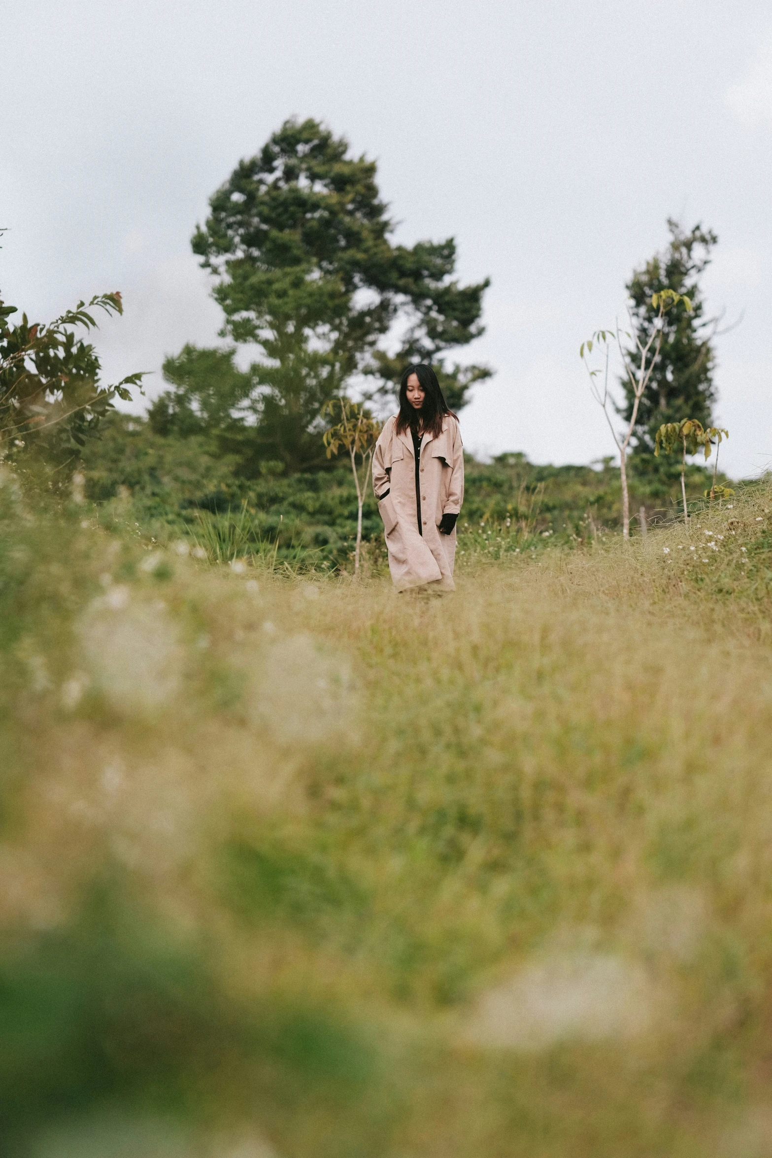 an asian woman with long hair wearing a jacket and walking alone