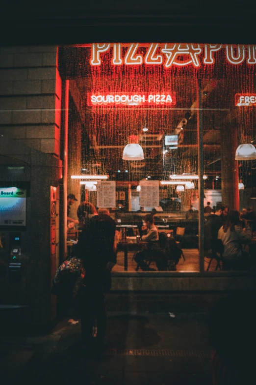 a busy diner with neon lights is pictured at night