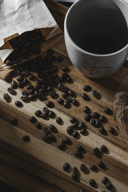 a table with a cup of coffee and a few beans