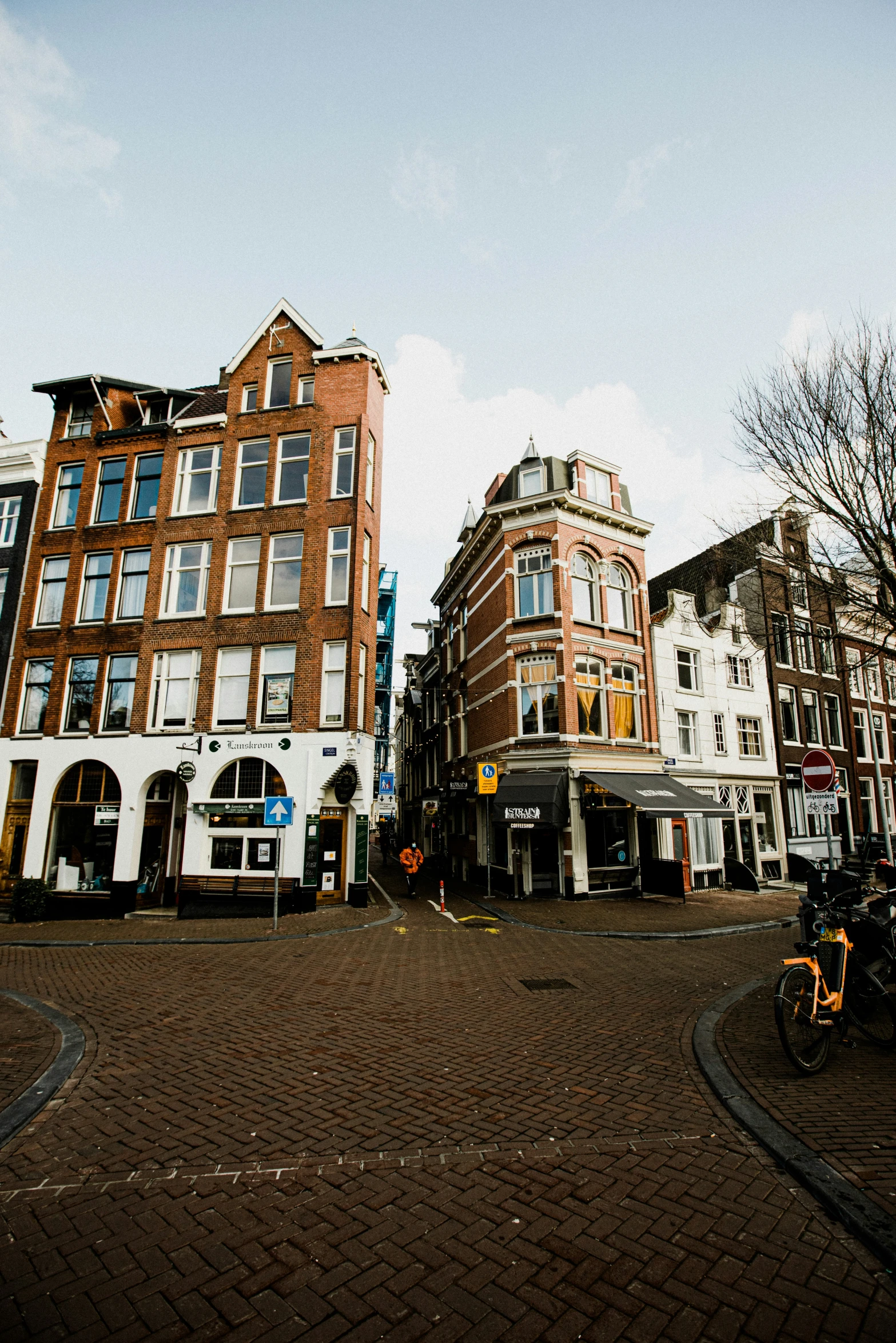 two bicycles are parked next to tall brick buildings