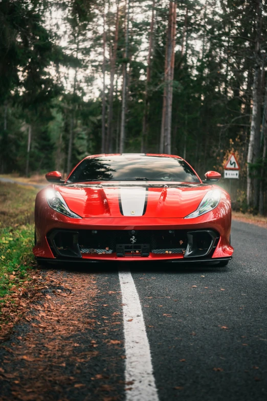 a sports car drives down the road next to some trees