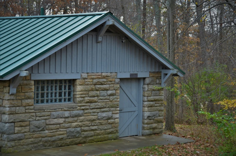 a brick building with an arched window sitting in the woods