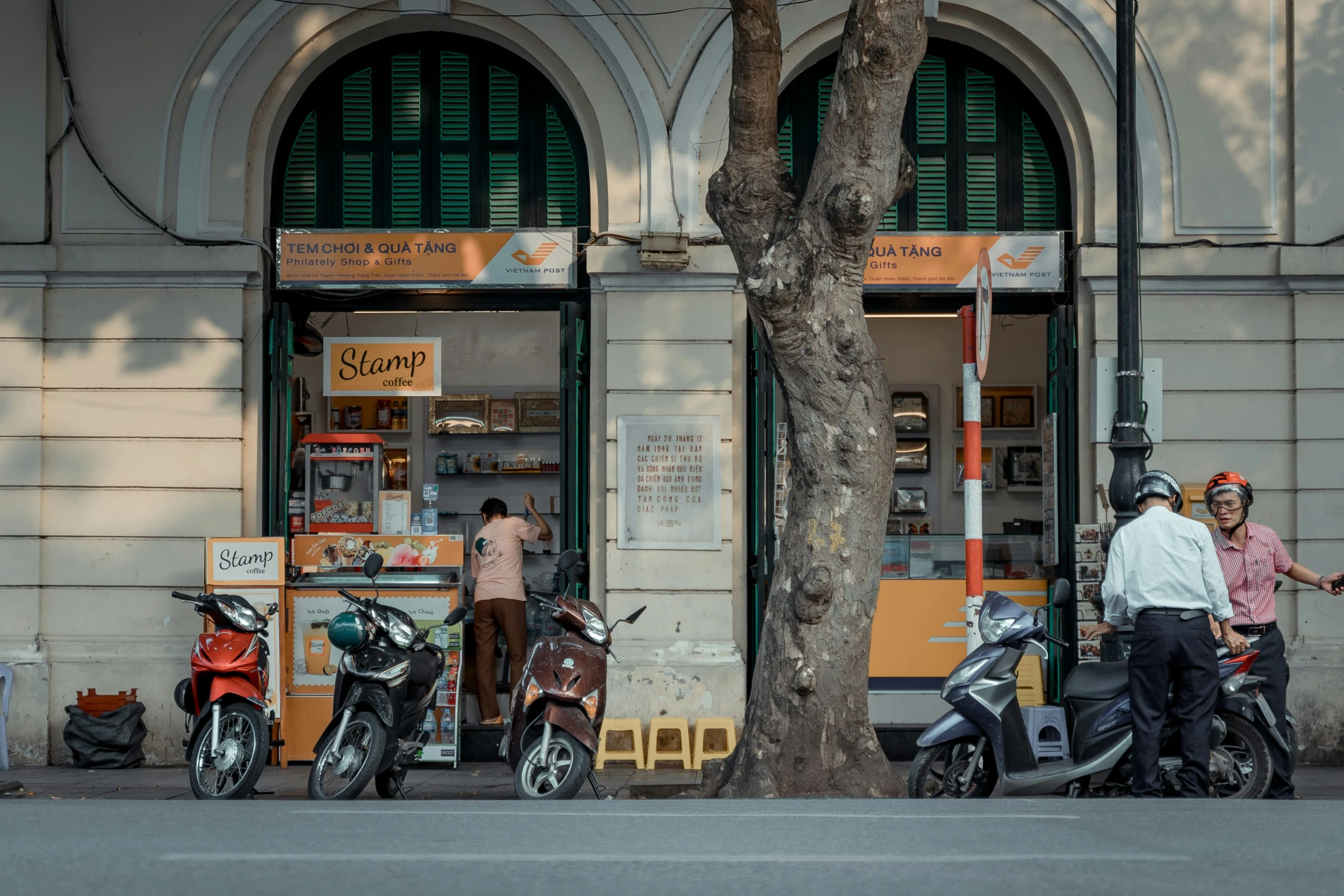 two men and two motorcycle parked in front of a convenience store