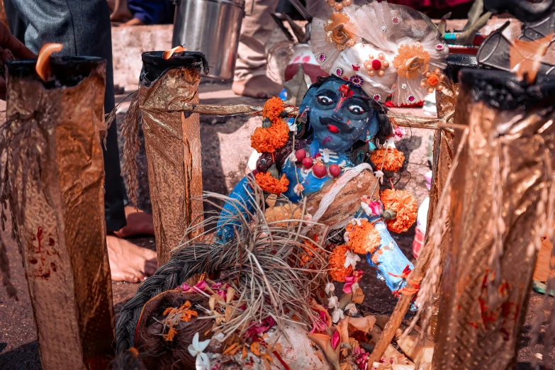 an idol sits on the ground near poles