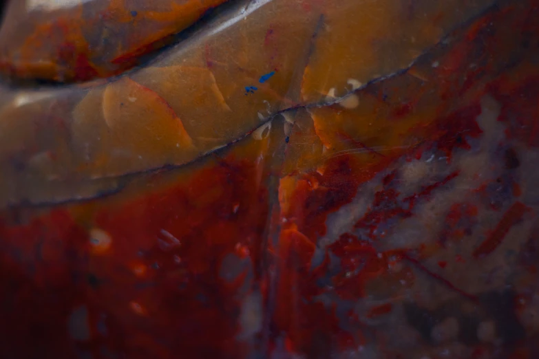 close up of an orange red and black vase