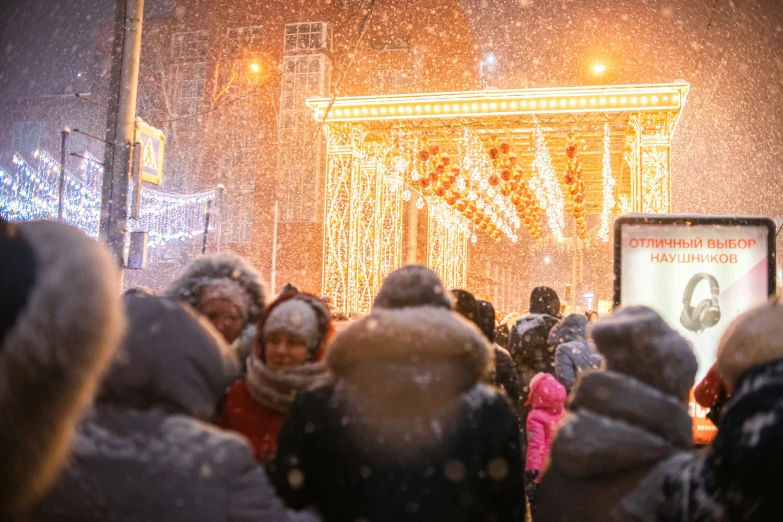 a group of people in winter attire walking down the street