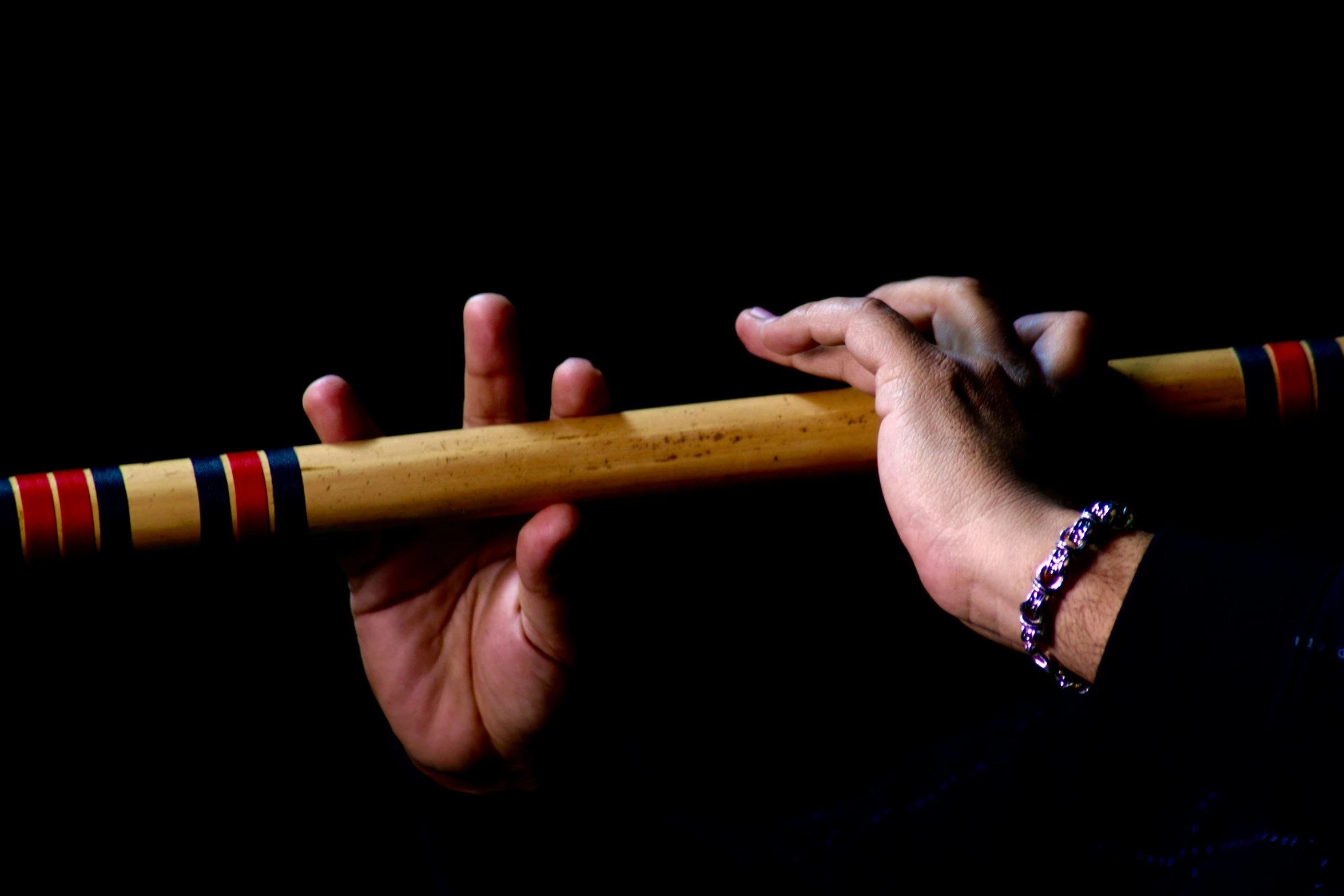 a man's hand holding on to a wooden stick