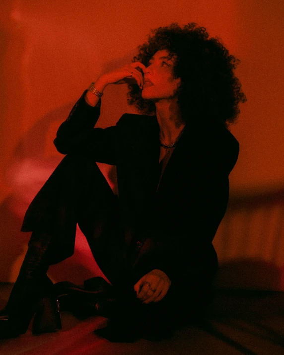 a woman sitting on the ground wearing black