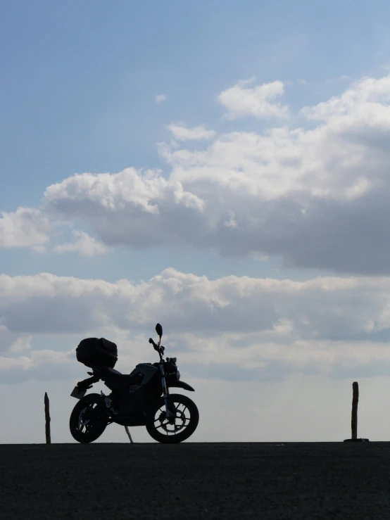 a motor cycle parked against the sky on a desert