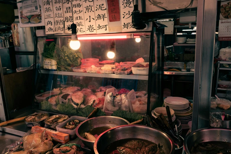 an oriental food stand has multiple pots and pans on it