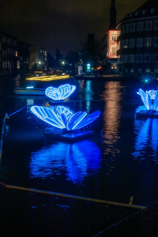 a couple of boats floating down a river at night